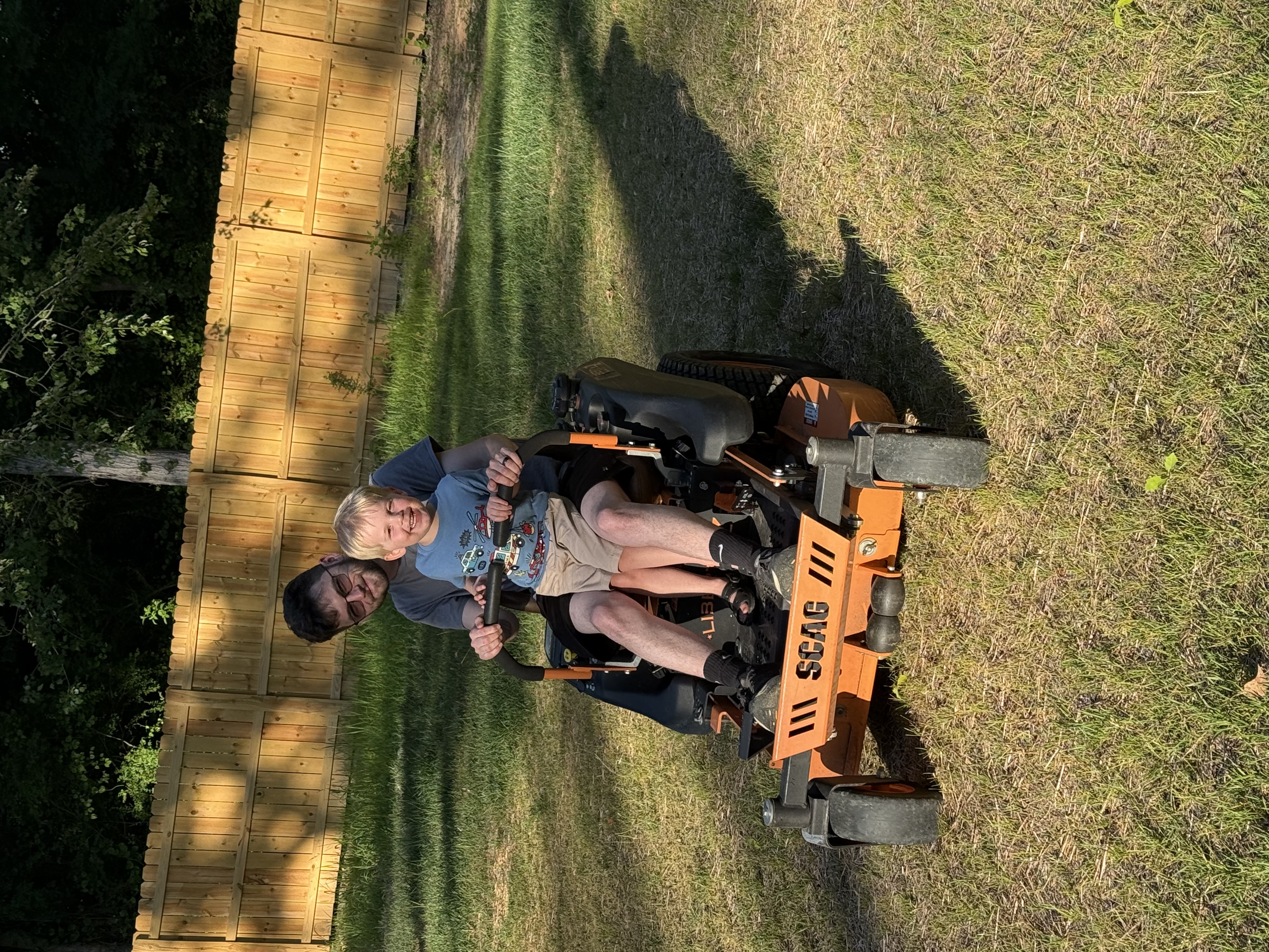 Randy and his son on the Scag mower